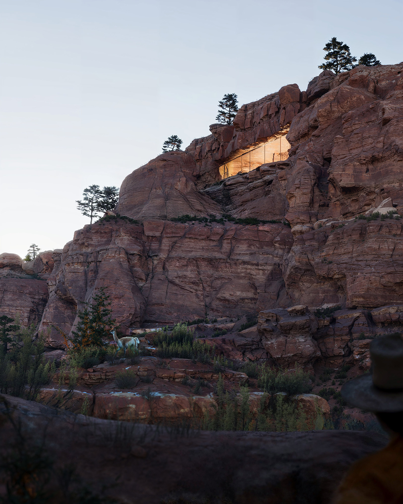 Exterior rendering, A minimalist architectural retreat carved into a rugged red rock cliff, softly illuminated at dusk and seamlessly blending into the natural canyon landscape.