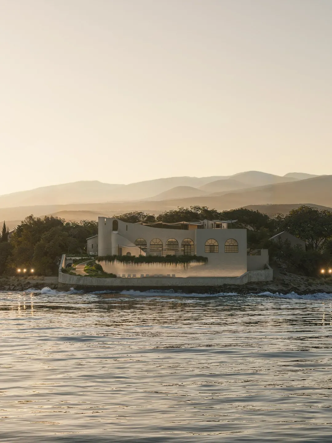 Riverpark Dark engineering brick residential apartment building with arched window reveals overlooking snow-covered riverside park in winter — architectural exterior rendering