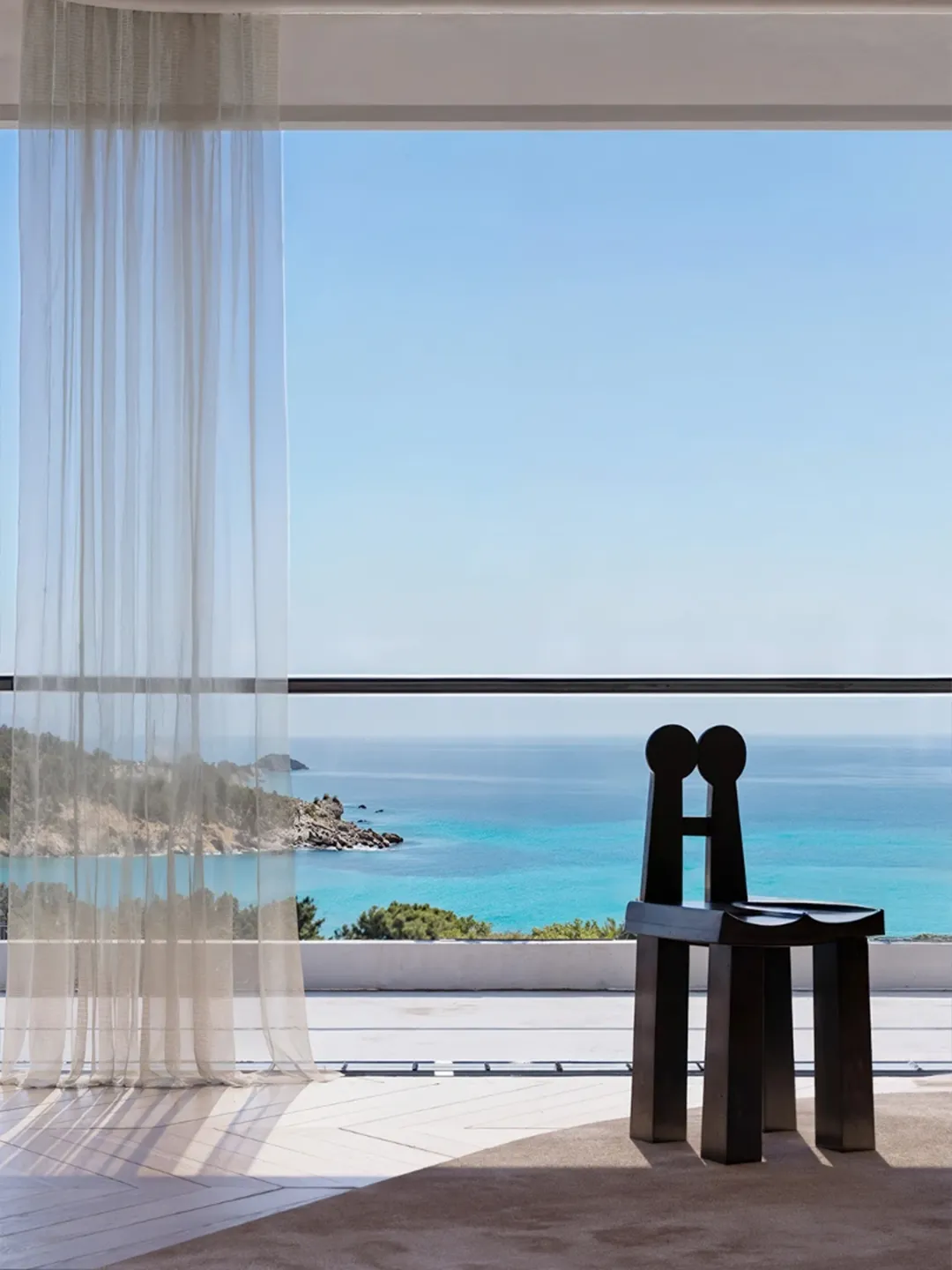 Contemporary villa interior with sculptural ebonized chair overlooking turquoise coastal sea — architectural interior rendering